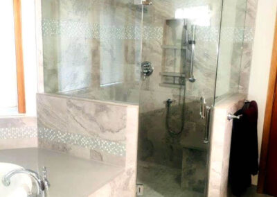 Turning a small dark corner shower in a larger open more spacious and luxurious shower with a bench seat and niche.