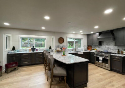 Creating a functional useable space for a difficult kitchen layout by adding a peninsula and updating appliances, cabinets, countertops and backsplash.